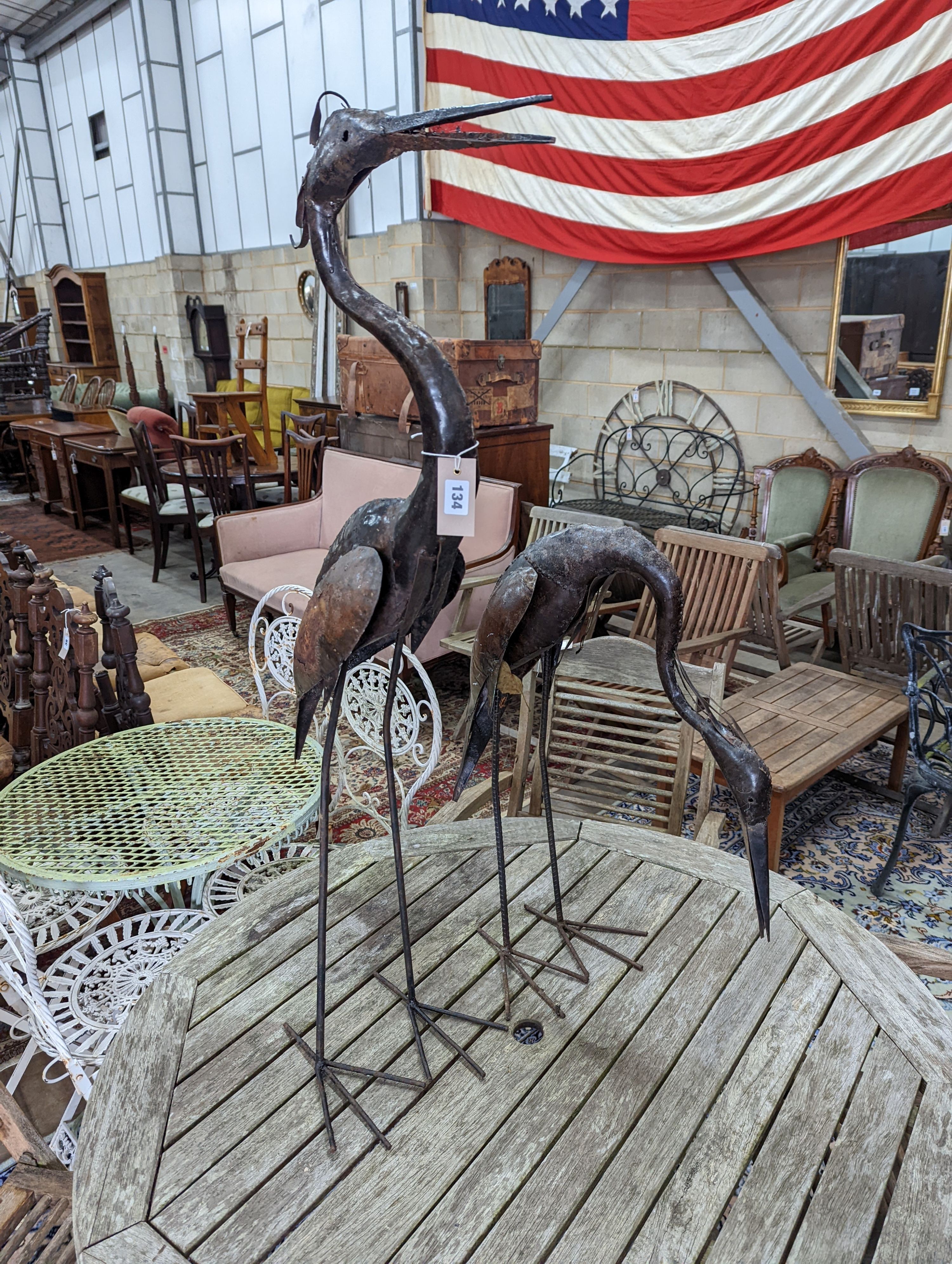 A pair of weathered metal heron garden ornaments, larger 108cm high